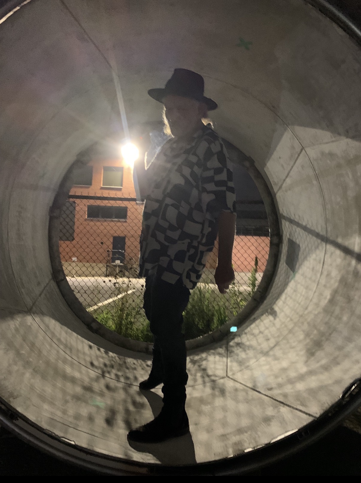Fast Eddie standing inside a circular concrete tunnel