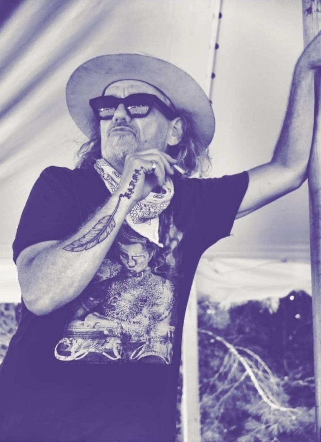 Purple-toned portrait of Fast Eddie in a hat and sunglasses