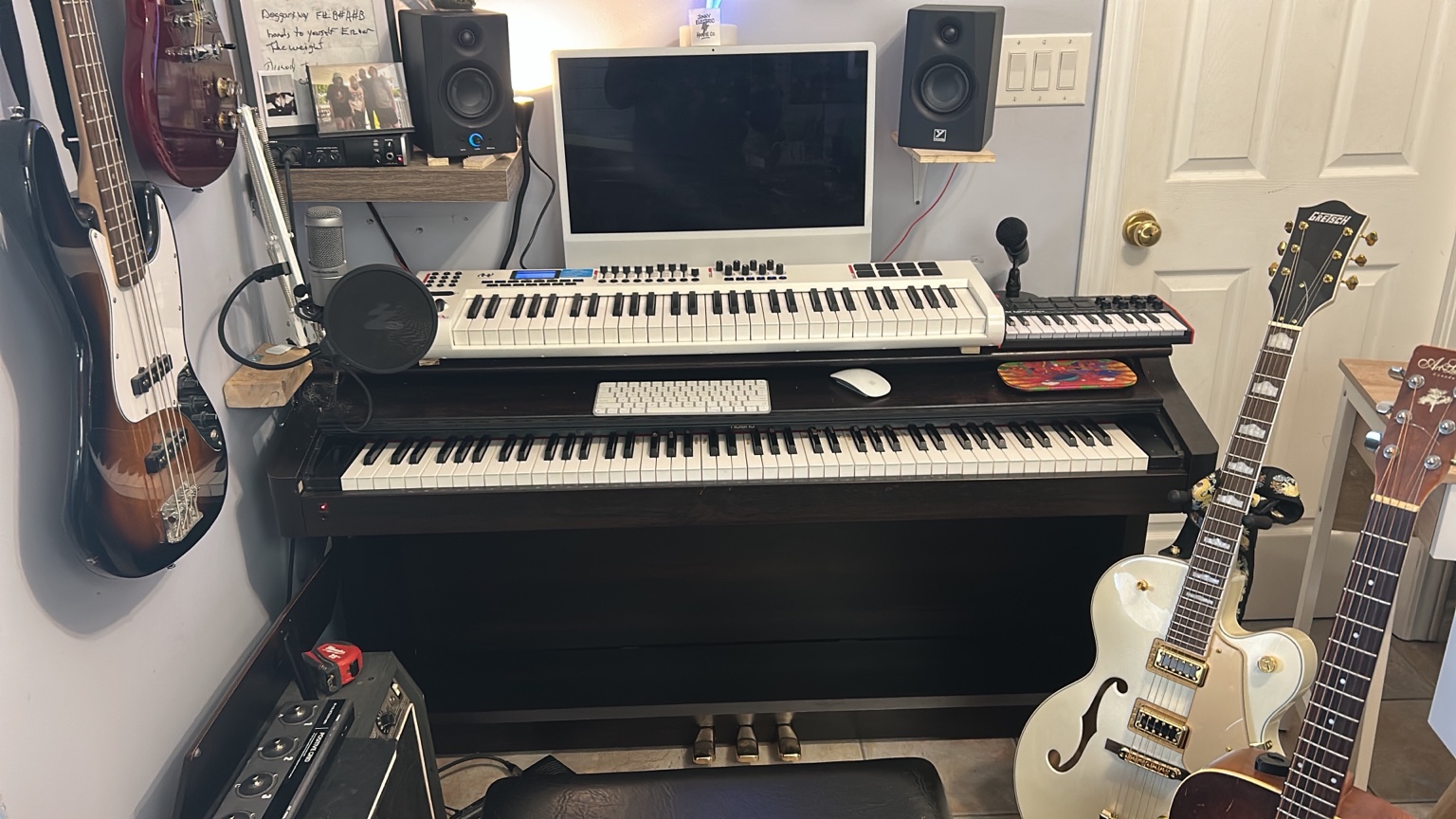 Jonny Electric's kitchen studio with guitars, keyboards, computer, speakers and recording equipment