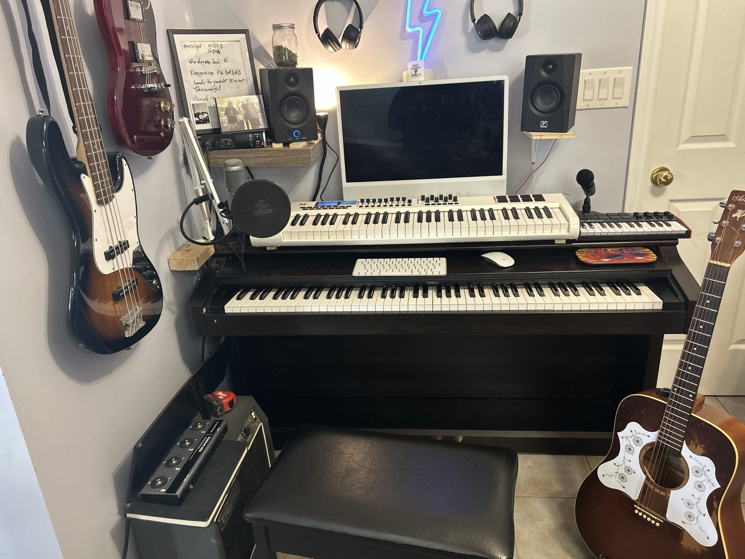 Wide view of the kitchen studio with guitars and illuminated lightning bolt
